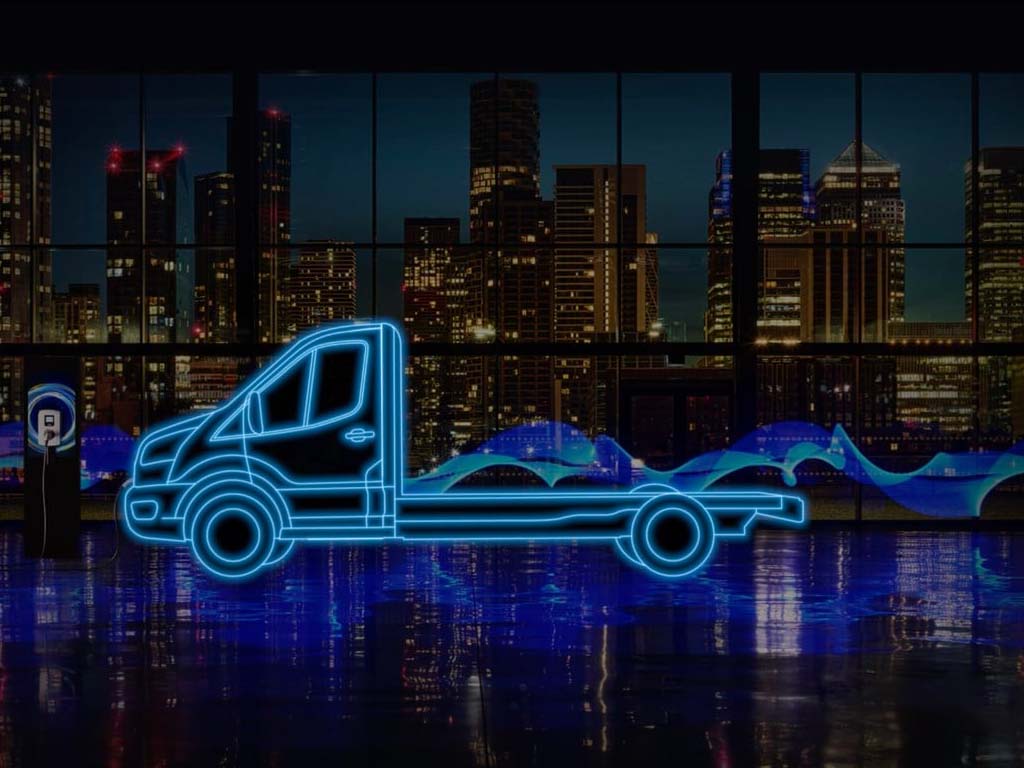Ford Etransit chassis cabine en néon parqué dans un immeuble de nuit avec vue sur la ville